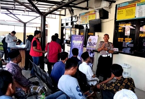 Personel Satlantas Polres Sampang saat menyampaikan sosialisasi kepada masyarakat. (KLIKMADURA)
