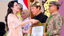 Kepala Disdikbud Pamekasan Basri Yulianto menerima penghargaan dari Balai Bahasa Provinsi Jawa Timur yang diwakili TP PKK Provinsi Jawa Timur, Arumi Bachsin Emil Dardak, Rabu (21/10/2026). (ISTIMEWA)