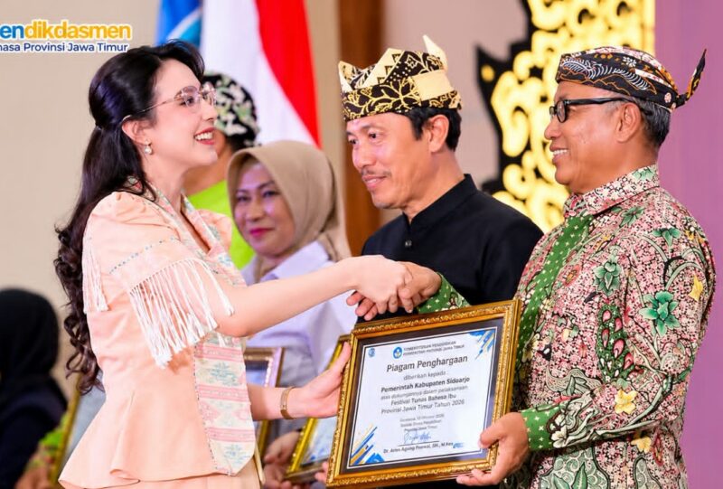 Kepala Disdikbud Pamekasan Basri Yulianto menerima penghargaan dari Balai Bahasa Provinsi Jawa Timur yang diwakili TP PKK Provinsi Jawa Timur, Arumi Bachsin Emil Dardak, Rabu (21/10/2026). (ISTIMEWA)