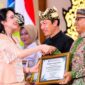 Kepala Disdikbud Pamekasan Basri Yulianto menerima penghargaan dari Balai Bahasa Provinsi Jawa Timur yang diwakili TP PKK Provinsi Jawa Timur, Arumi Bachsin Emil Dardak, Rabu (21/10/2026). (ISTIMEWA)
