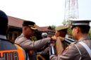 Kapolres Sampang AKBP Anang Hardiyanto memasangkan pin kepada personel Satpol PP sebagai tanda dimulainya operasi patuh semeru 2026. (KLIKMADURA)