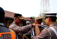 Kapolres Sampang AKBP Anang Hardiyanto memasangkan pin kepada personel Satpol PP sebagai tanda dimulainya operasi patuh semeru 2026. (KLIKMADURA)