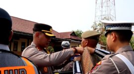 Kapolres Sampang AKBP Anang Hardiyanto memasangkan pin kepada personel Satpol PP sebagai tanda dimulainya operasi patuh semeru 2026. (KLIKMADURA)