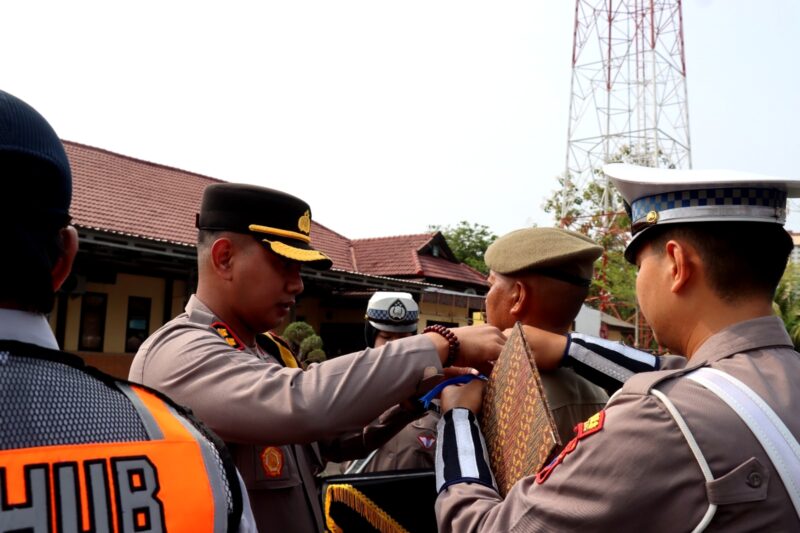 Kapolres Sampang AKBP Anang Hardiyanto memasangkan pin kepada personel Satpol PP sebagai tanda dimulainya operasi patuh semeru 2026. (KLIKMADURA)