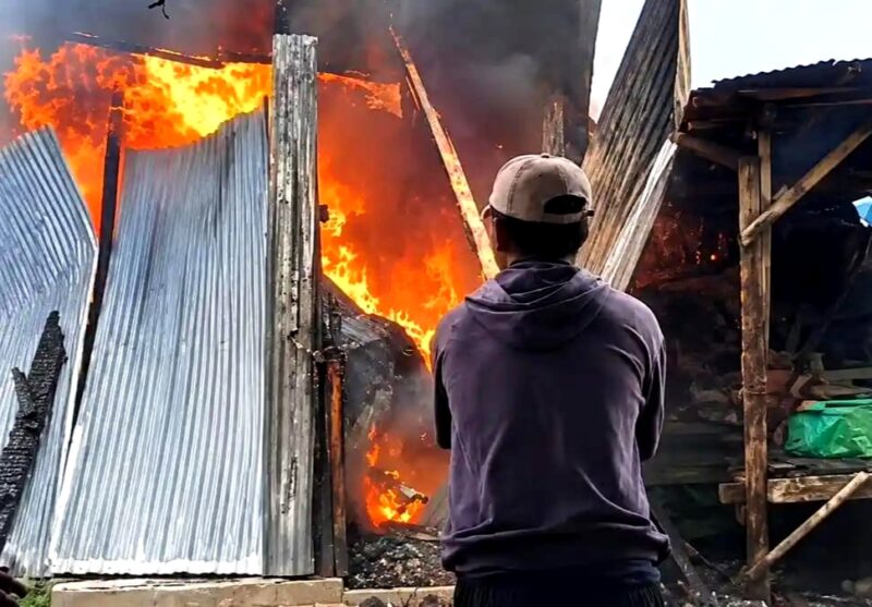 Salah satu warga berupaya memadamkan api yang melalap lapak di Pasar Tambelangan, Sampang. (KLIKMADURA)