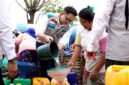 Manager PLN UP3 Madura, Radea Cakrawala Nusantara menuangkan air bersih ke wadah milik warga. (KLIKMADURA)