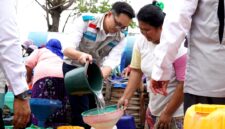 Manager PLN UP3 Madura, Radea Cakrawala Nusantara menuangkan air bersih ke wadah milik warga. (KLIKMADURA)