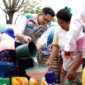Manager PLN UP3 Madura, Radea Cakrawala Nusantara menuangkan air bersih ke wadah milik warga. (KLIKMADURA)